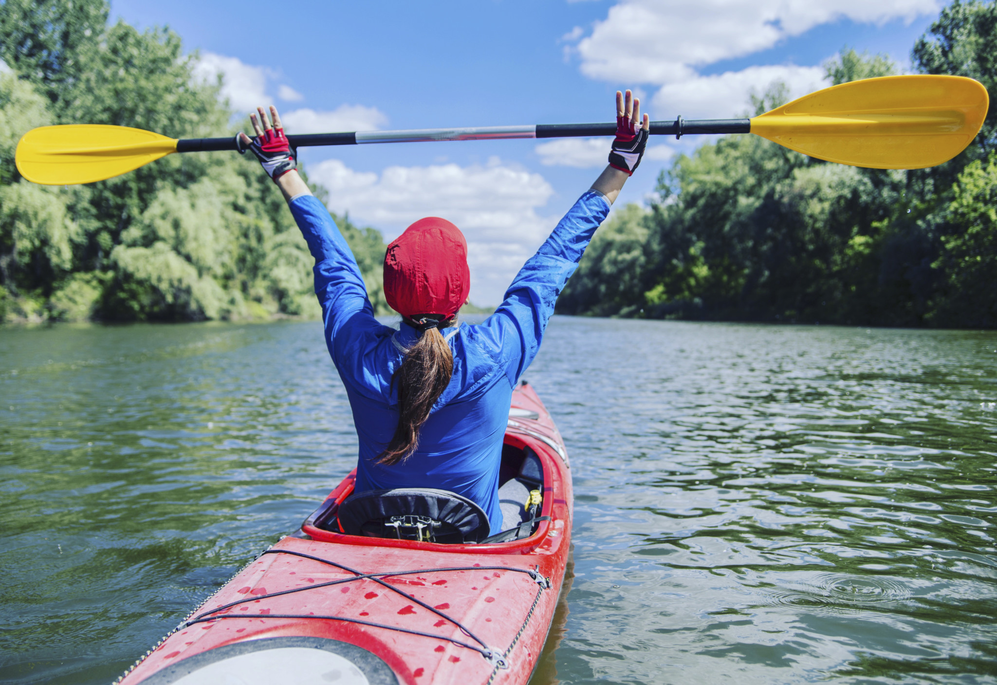 A girl rafts down the river on a kayak.