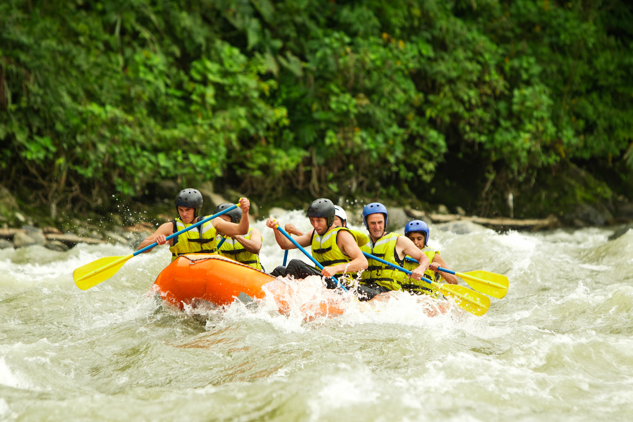 Group Of Mixed Tourist Men And Women With Guided By Professional Pilot On Whitewater River Rafting In Ecuador