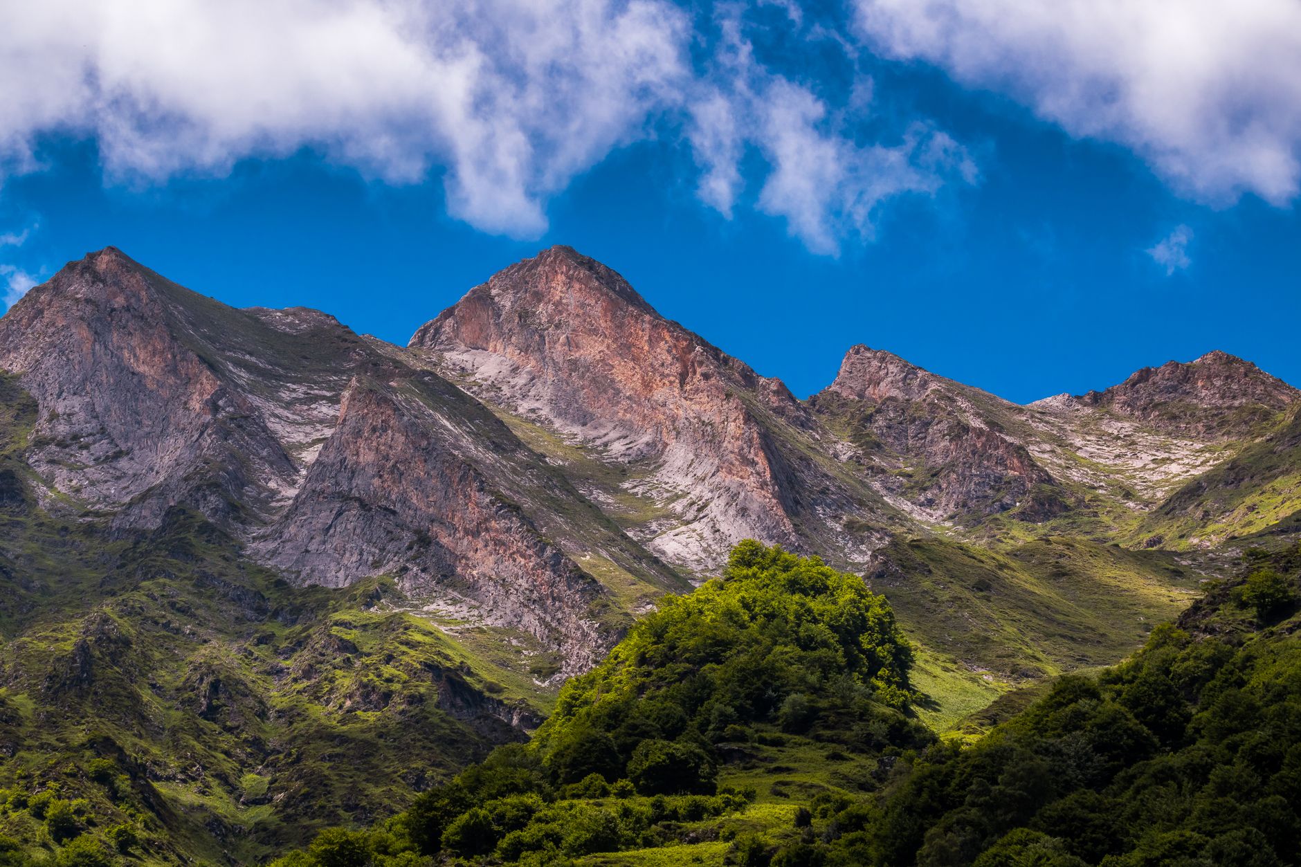 Paisaje del Pirineo en verano, valles verdes bajo la alta montaña
