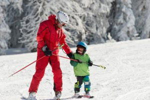 Profesor de esquí enseñando a su alumno